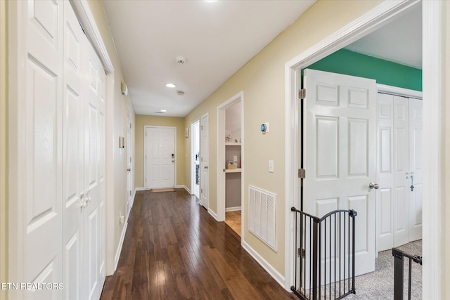hall featuring recessed lighting, dark wood finished floors, visible vents, and baseboards
