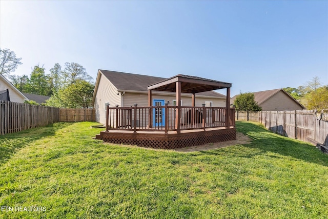 rear view of property with a wooden deck, a fenced backyard, and a lawn