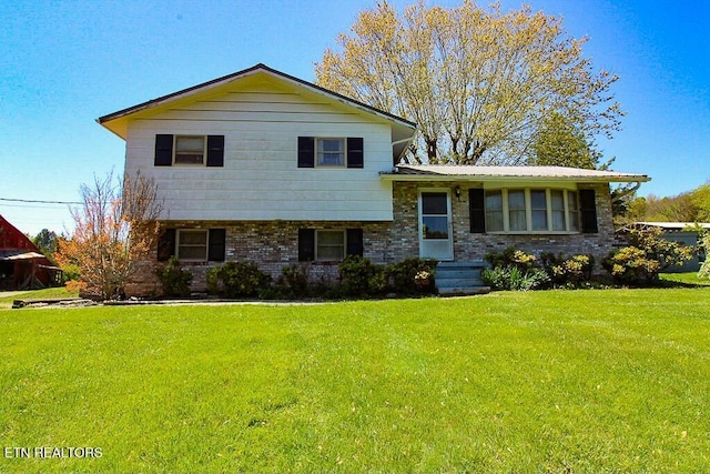 tri-level home featuring brick siding, a front lawn, and metal roof