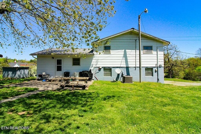 rear view of house with central air condition unit, a yard, and a patio