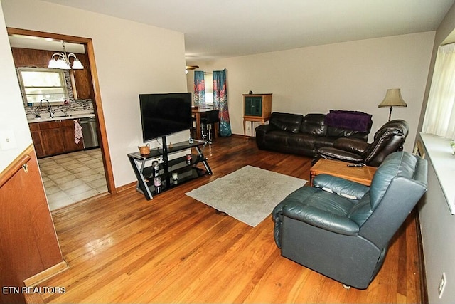 living room featuring light wood-style floors and an inviting chandelier