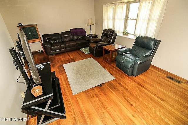 living room with wood finished floors and visible vents
