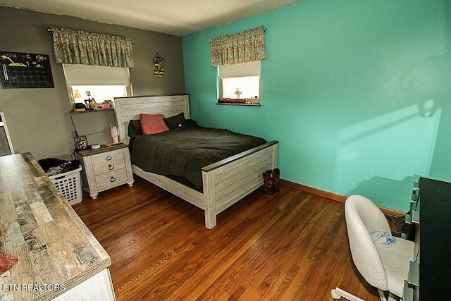 bedroom with baseboards and wood finished floors