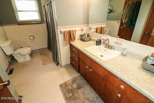 full bathroom with a wainscoted wall, visible vents, toilet, vanity, and tile walls