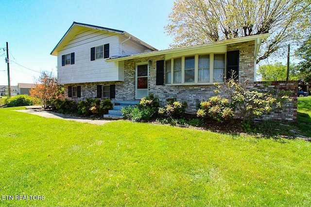 split level home with brick siding and a front yard