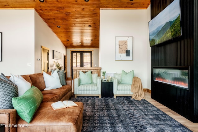 living area with wood ceiling, wood finished floors, and a glass covered fireplace
