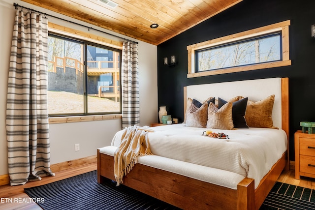 bedroom with wooden ceiling, vaulted ceiling, wood finished floors, and baseboards