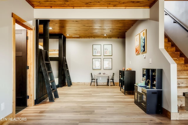 interior space featuring stairway, light wood-style flooring, and wooden ceiling
