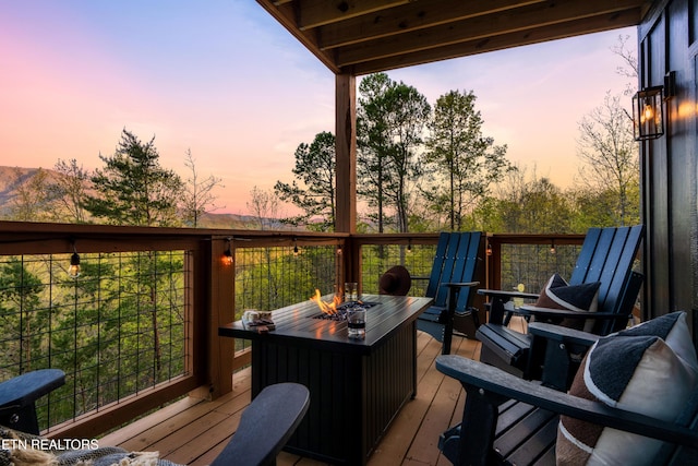 deck at dusk featuring an outdoor fire pit