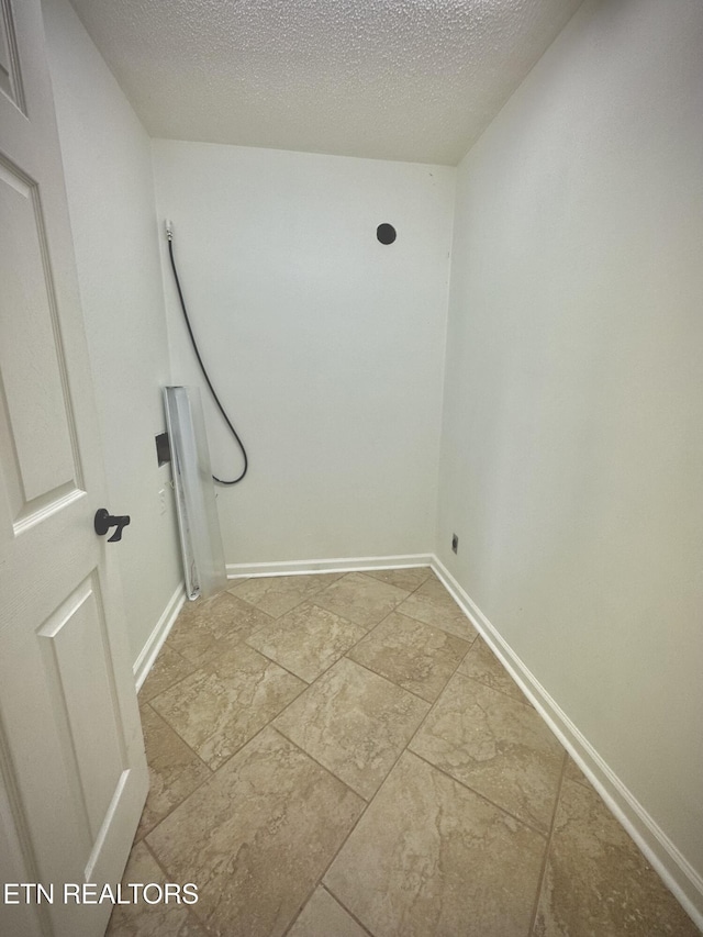 11709 Black Powder Dr, Knoxville, TN 37934 - clothes washing area featuring baseboards, stone finish flooring, and a textured ceiling
