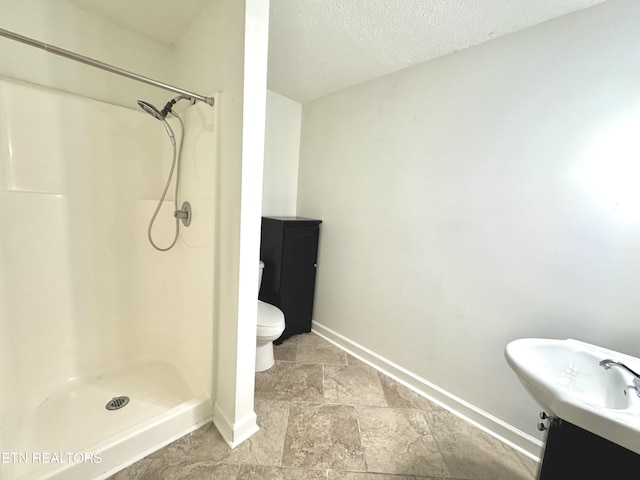 11709 Black Powder Dr, Knoxville, TN 37934 - bathroom featuring a textured ceiling, a sink, toilet, baseboards, and a shower stall