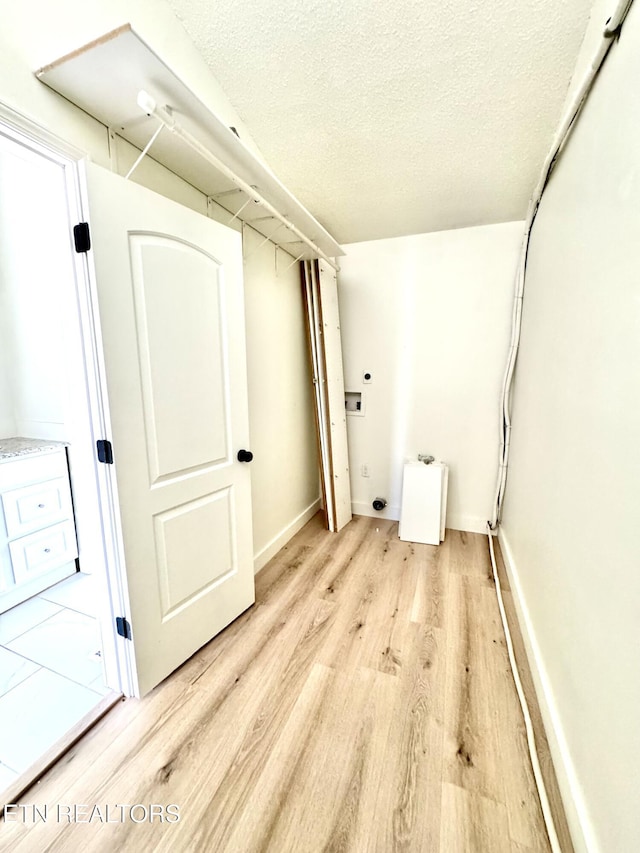 11709 Black Powder Dr, Knoxville, TN 37934 - laundry area with hookup for an electric dryer, light wood-style floors, baseboards, washer hookup, and a textured ceiling