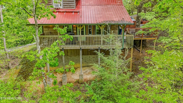 back of house with metal roof and a wooden deck