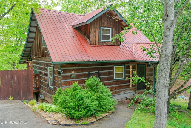 view of front of property featuring fence and metal roof