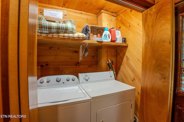 clothes washing area with independent washer and dryer, laundry area, and wood walls