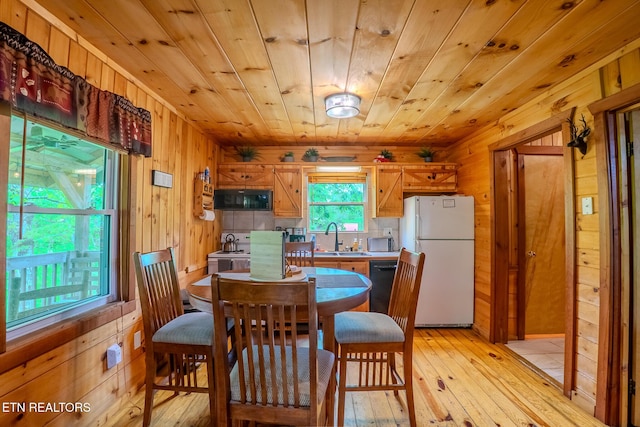 dining area featuring wood ceiling, wood walls, and light wood-style flooring
