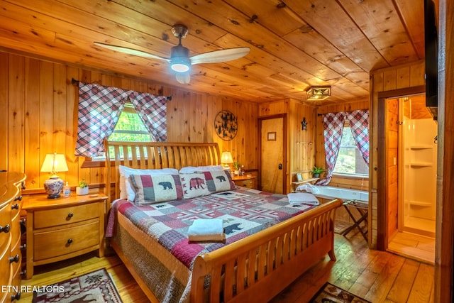 bedroom with wood ceiling, multiple windows, wood walls, and light wood-type flooring
