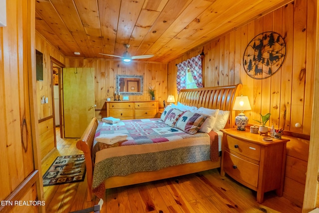 bedroom with wooden walls, wooden ceiling, and hardwood / wood-style flooring
