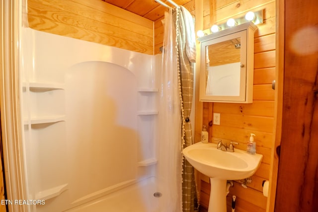 full bathroom with wooden walls and a shower stall