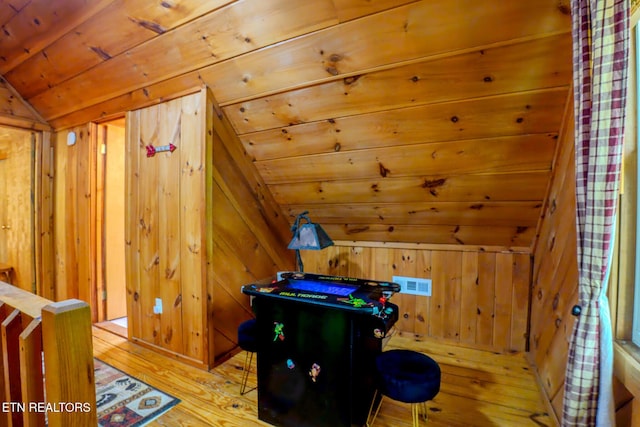 playroom featuring wooden walls, visible vents, hardwood / wood-style floors, wooden ceiling, and vaulted ceiling