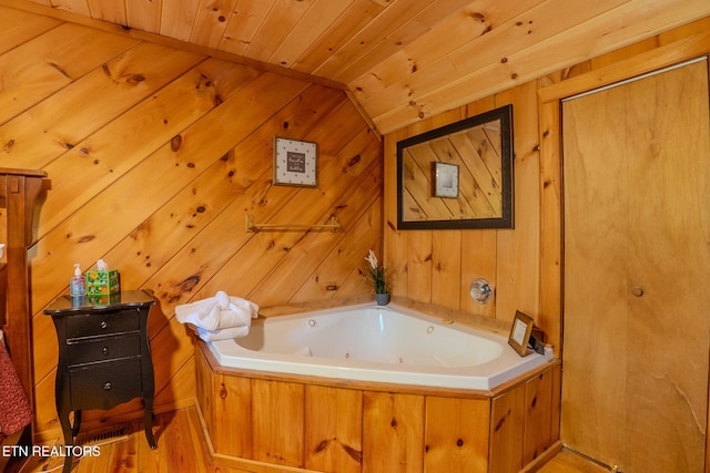 full bathroom featuring wooden walls, a whirlpool tub, wooden ceiling, wood finished floors, and lofted ceiling