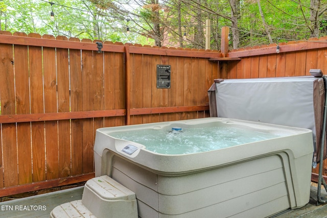 exterior space featuring a hot tub and fence
