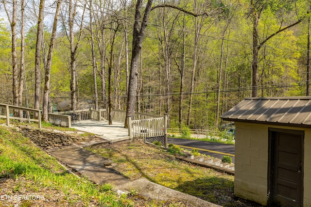 view of yard featuring an outbuilding and a wooded view