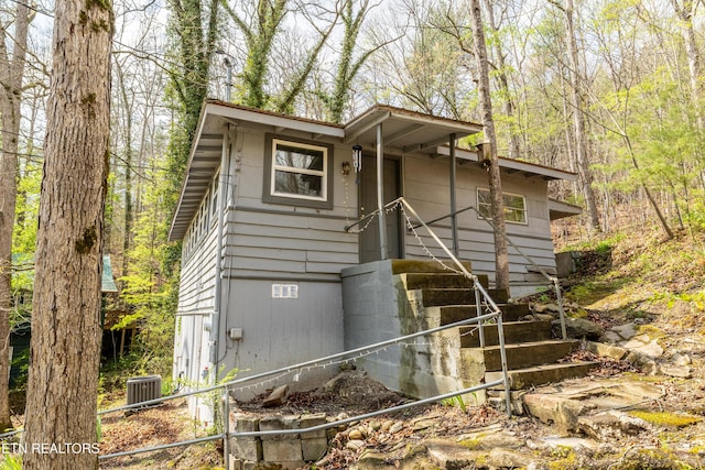 view of front of home with central AC and fence