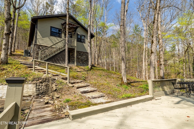 view of side of property featuring stairs, central air condition unit, and a deck