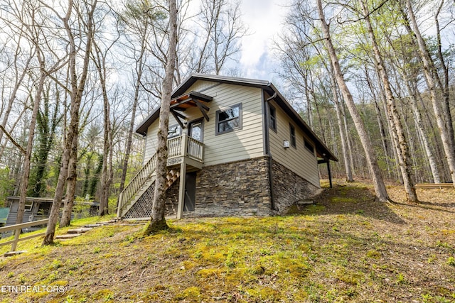 view of home's exterior with stairs and stone siding