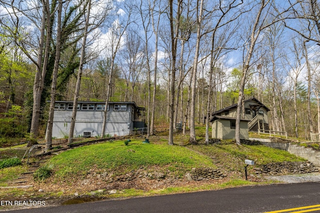 view of yard featuring an outbuilding and a wooded view