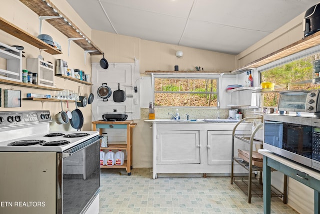 kitchen featuring open shelves, a sink, electric stove, lofted ceiling, and light floors