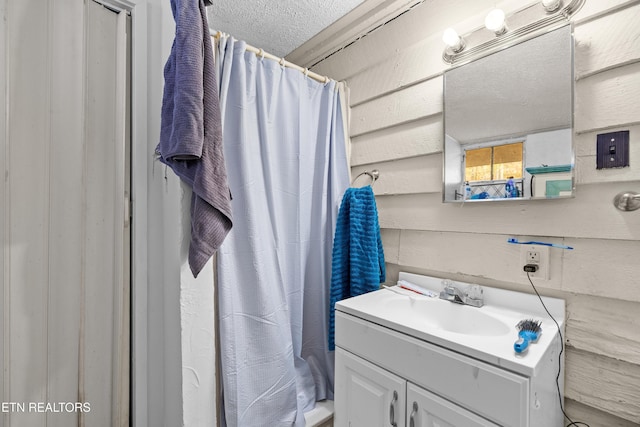 bathroom featuring vanity, a textured ceiling, and a shower with shower curtain