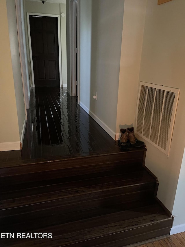 stairway with baseboards, wood finished floors, and visible vents