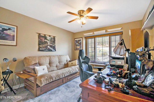 office space with ceiling fan and baseboards
