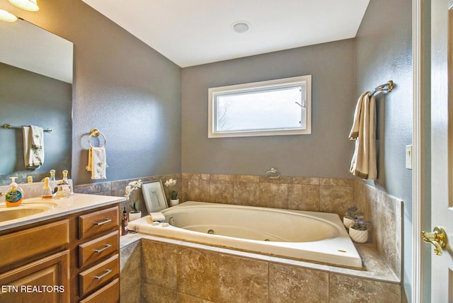 full bath featuring vanity and a jetted tub