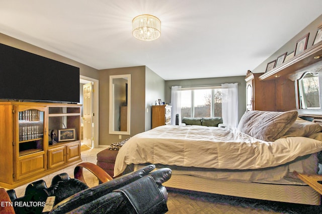 bedroom featuring a chandelier and baseboards