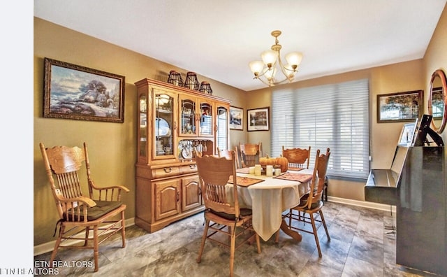 dining area with a chandelier and baseboards