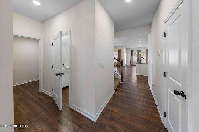 hallway featuring stairs, recessed lighting, baseboards, and dark wood finished floors