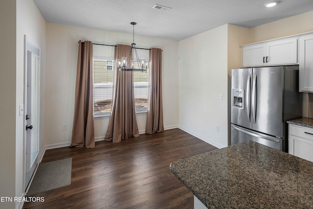 kitchen featuring visible vents, dark wood-style floors, stainless steel refrigerator with ice dispenser, white cabinetry, and a chandelier