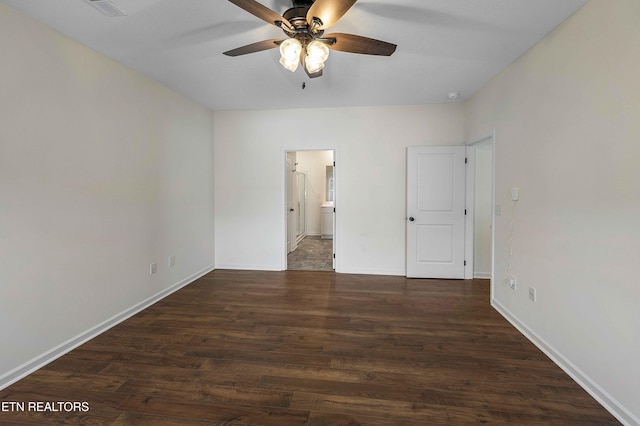 unfurnished bedroom featuring baseboards, ensuite bath, wood finished floors, and visible vents
