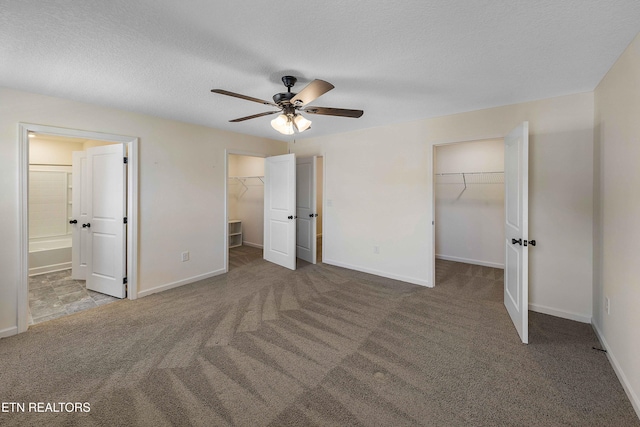 unfurnished bedroom featuring connected bathroom, a spacious closet, carpet, and a closet