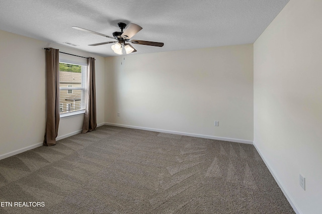 spare room with carpet floors, a textured ceiling, a ceiling fan, baseboards, and visible vents