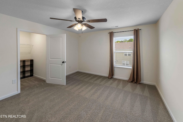 unfurnished bedroom featuring baseboards, a textured ceiling, carpet, and a ceiling fan