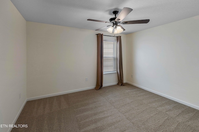 unfurnished room with light colored carpet, a ceiling fan, and baseboards