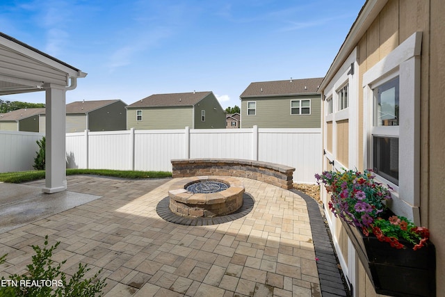 view of patio with a residential view, a fenced backyard, and an outdoor fire pit