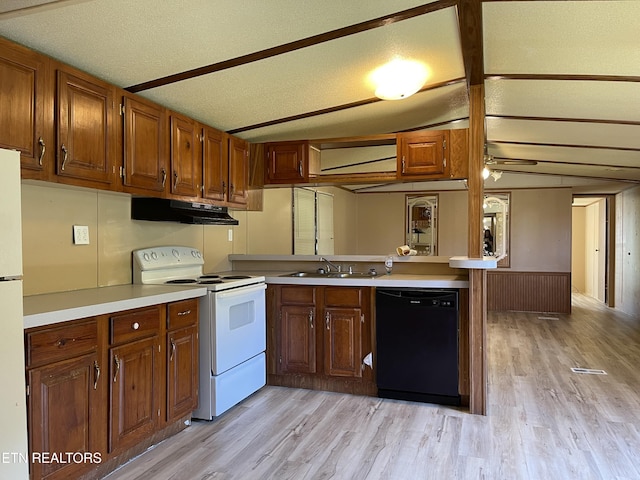 kitchen featuring under cabinet range hood, a sink, white appliances, light wood-type flooring, and a peninsula