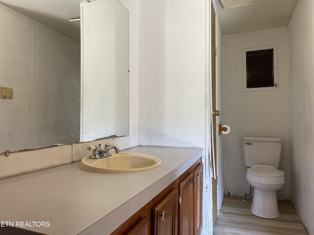 bathroom with wood finished floors, vanity, and toilet