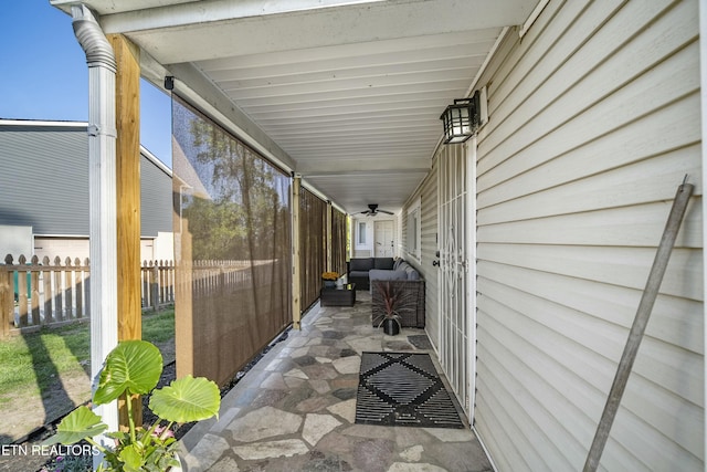 view of patio / terrace with fence, a ceiling fan, and an outdoor living space