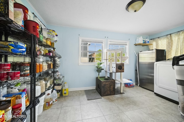 washroom featuring washer / dryer, tile patterned flooring, and baseboards